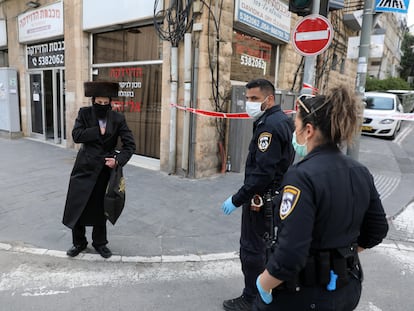 Dos agentes identifican a un ultraortodoxo en un acceso al barrio de Mea Shearim, el domingo en Jerusalén.