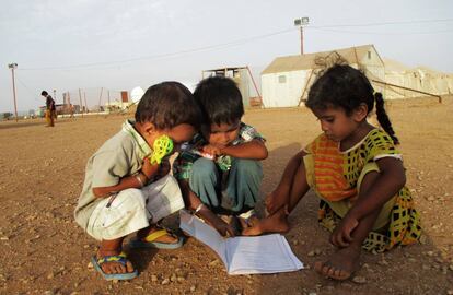 Unos niños observan un cuaderno escolar en el campo de refugiados de Marzaki (Yibuti).