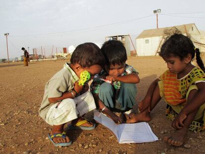Unos niños observan un cuaderno escolar en el campo de refugiados de Marzaki (Yibuti).