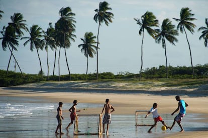 Varios niños juegan al fútbol en las playas de Natal, en Brasil.
