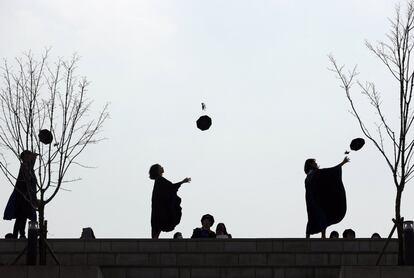 Graduados vestidos con togas lanzan sus birretes al aire en la Universidad de Yonsei en Seúl (Corea del Sur).