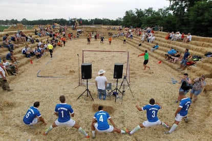 Jugadores entrenan antes de que comience el torneo de fúbol sobre paja.