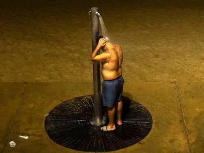Un hombre se refrescaba en julio de 2024 en una ducha de la playa de la Barceloneta.