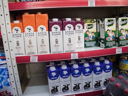 Un estante de un supermercado con cartones de leche y productos lácteos.