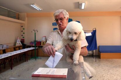 Un hombre vota en las elecciones generales griegas junto a su perro en Atenas, el 7 de julio de 2019.