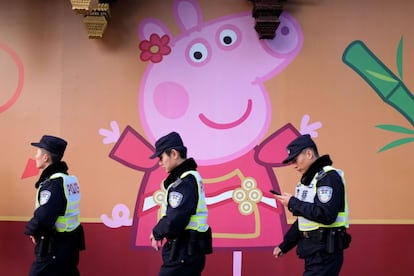 Policiais caminham diante de uma ilustração da Peppa Pig em frente aos jardins de Yu Yuan, em Shanghai, na China. A porquinha é considerada um emblema da contracultura e vista como transgressora, mas sua popularidade só fez crescer com a chegada do Ano do Porco