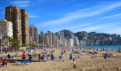 Turistas tomando el sol o bañándose, ayer, en la playa de Levante de Benidorm.