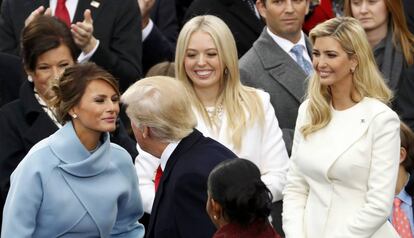 Donald Trump beija a sua esposa ao lado das filhas.