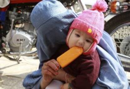 Un niño come un helado con su madre en Herat (Afganistán).