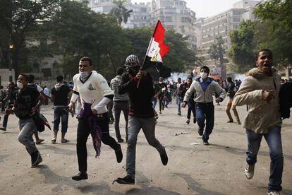 Manifestantes egipcios huyen de la policía durante las protestas en la plaza Tahrir contra el presidente egipcio Mohamed Morsi