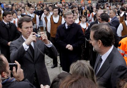 El presidente de la Xunta, Alberto Núñez Feijóo, fotografía al presidente del Gobierno, Mariano Rajoy y a la persona que le prestó la cámara tras el funeral en memoria de Fraga.