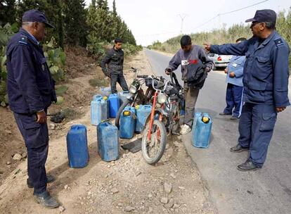 Aduaneros marroquíes detienen en una carretera secundaria, cerca de Oujda, a dos chavales que transportaban, cada uno, en su motocicleta, seis bidones de gasolina argelina. Los combustibles argelinos entran de contrabando en Marruecos. No en balde el litro de gasolina cuesta en Argelia 0,45 euros, la mitad de su precio en Marruecos.