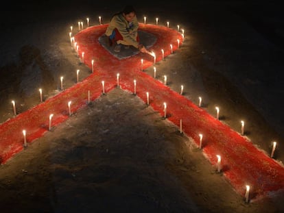 An Indian sex worker lights candles forming the shape of a ribbon as part of an awareness event on the occasion of World AIDS Day in Siliguri on December 1, 2018. - World AIDS Day has been observed today since 1988 to raise awareness of the AIDS pandemic. (Photo by DIPTENDU DUTTA / AFP)