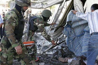 Soldados iraquíes inspeccionan el lugar de uno de los atentados, donde yace un fallecido.