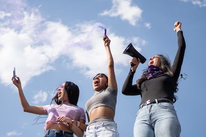 Tres jóvenes marchan para conmemorar el Día Internacional de la Mujer en Ciudad de México.
