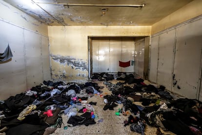 Interior de una celda de la prisión militar llena de mantas y otras prendas tiradas en el suelo.