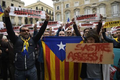 Manifestantes con esteladas y pancartas que dicen "libertad a presos políticos" durante la concentración en la plaza de Sant Jaume de Barcelona.