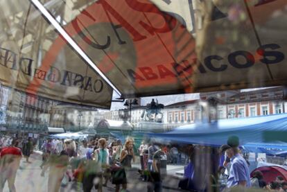 El campamento del Movimiento 15-M, reflejado en una tienda de paraguas y abanicos de la Puerta del Sol.