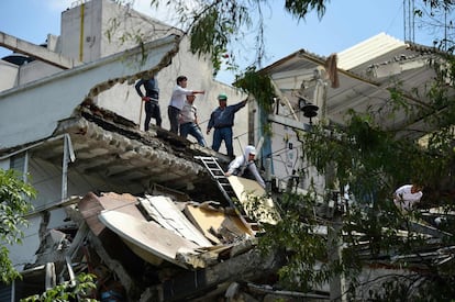 Un grup de persones observa els danys que el terratrèmol ha causat en un edifici a Ciutat de Mèxic.