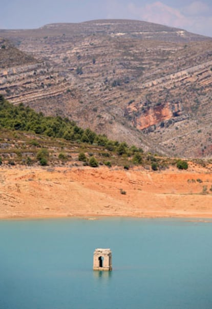 El campanario de una iglesia se asoma sobre el nivel del agua en el embalse de Tous, cerca de Valencia. El nivel del agua de los embalses ha disminuido de tal modo que en algunos lugares permite ver los restos de los pueblos anegados.