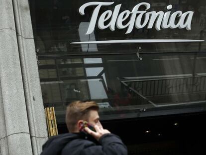 Un usuario habla por su m&oacute;vil junto a la sede de Telef&oacute;nica en Gran V&iacute;a.