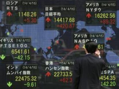 Un hombre observa información bursátil en una pantalla en la Bolsa de Tokio.