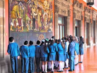 Escolares frente al mural de Diego Rivera ‘La colonización o llegada de Hérnan Cortés a Veracruz’, en el Palacio Nacional, en México DF.