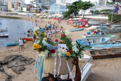 Un ciudadano en Salvador (Brasil) lleva flores como tributo a la playa de Río Vermelho, el 1 de febrero.