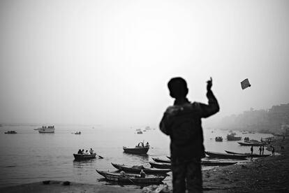 Un niño vuela una cometa desde en la orilla del río Ganges (India). / WALTER ASTRADA