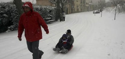 Un hombre y dos niños disfrutan de la copiosa nevada caída en Tarragona