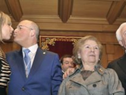 El nuevo presidente besa a su esposa, junto a sus padres, en el sal&oacute;n de plenos de la Diputaci&oacute;n.