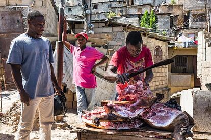 Alpha Ogust, de 35 años, vendedor de carne desde hace cinco, atiende a unos vecinos.
