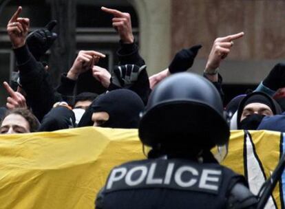 Varios manifestantes ayer ante un policía durante una protesta contra el Foro Económico de Davos en Ginebra (Suiza).