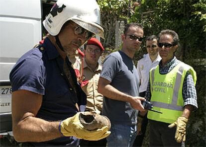 Un miembro de los Tedax muestra los resto del proyectil tras la explosión controlada.