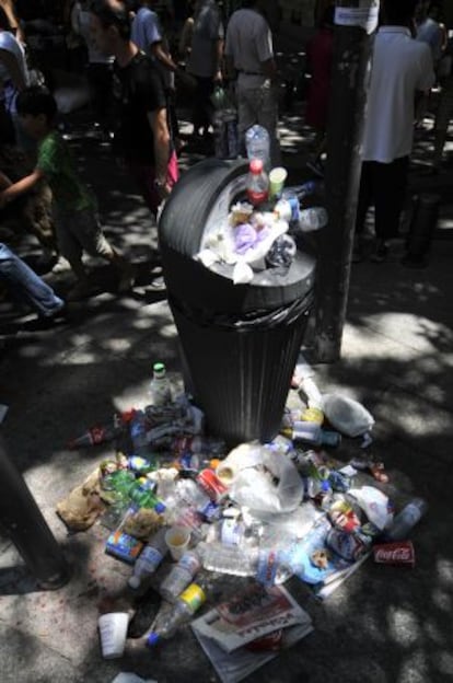 Una papelera rebosa de basura en el Rastro de Madrid.