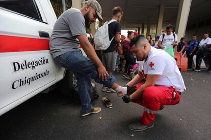 La presencia de la Guardia Nacional en el sur de México desde el affaire arancelario de junio es constante. En la imagen, un voluntario de la Cruz Roja guatemalteca ofrece atención medica a migrantes hondureños que avanzan en caravana para hacer su proceso legal migratorio, este jueves, en la aduana de Agua Caliente (Guatemala).