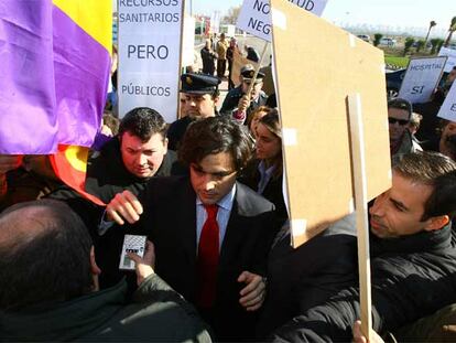 Varios manifestantes rodean a Juan José Güemes a las puertas del hospital de Parla.