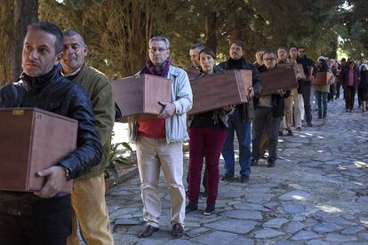 Un grupo de personas traslada restos de víctimas del franquismo exhumadas el pasado año en Cazalla de la Sierra (Sevilla).