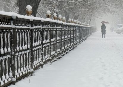 Una mujer pasea por un parque mientras nieva en Almaty (Kazajistán), el 11 de enero de 2018. 