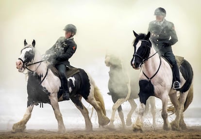 Miembros de la práctica de Escolta Honoraria de Caballería en la playa durante el 'Día de los Príncipes', en Scheveningen (Países Bajos). Los caballos y jinetes involucrados son sometidos a una prueba final al exponerlos a disparos, cañones, música y humo.