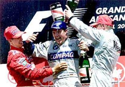 Ralf Schumacher (en el centro) es rociado de champaña por su hermano Michael (a la izquierda) y por Mika Hakkinen.