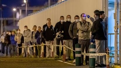 Un guardia de seguridad toma la temperatura a los trabajadores del primer turno de la factoría de Renault de Sevilla, este jueves.