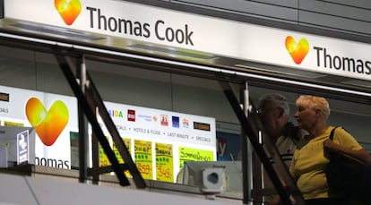 Dos pasajeros caminan frente a un escaparate de la empresa brit&aacute;nica Thomas Cook, en el aeropuerto internacional de Frankfurt (Alemania). 