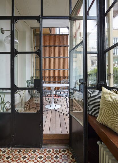 En la fachada posterior de la vivienda, la terraza con un pavimento de lamas de teca da a un patio del Eixample.