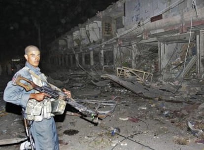 Un policía afgano vigila el lugar de la explosión de un camión bomba en Kandahar.