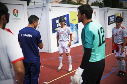 Los futbolistas escuchan las últimas indicaciones del entrenador antes de salir al campo. Los porteros son los únicos que ven.