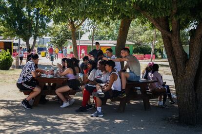 Un grupo de jóvenes descansa en la sombra de un árbol del centro municipal La Pollina, en Fuenlabrada. 