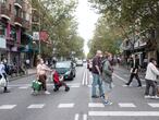 Peatones cruzan un paso de cebra en la calle Alcalá, cerca de la boca de Metro de Pueblo Nuevo. A la derecha la zona verde, a la izquierda la zona roja.