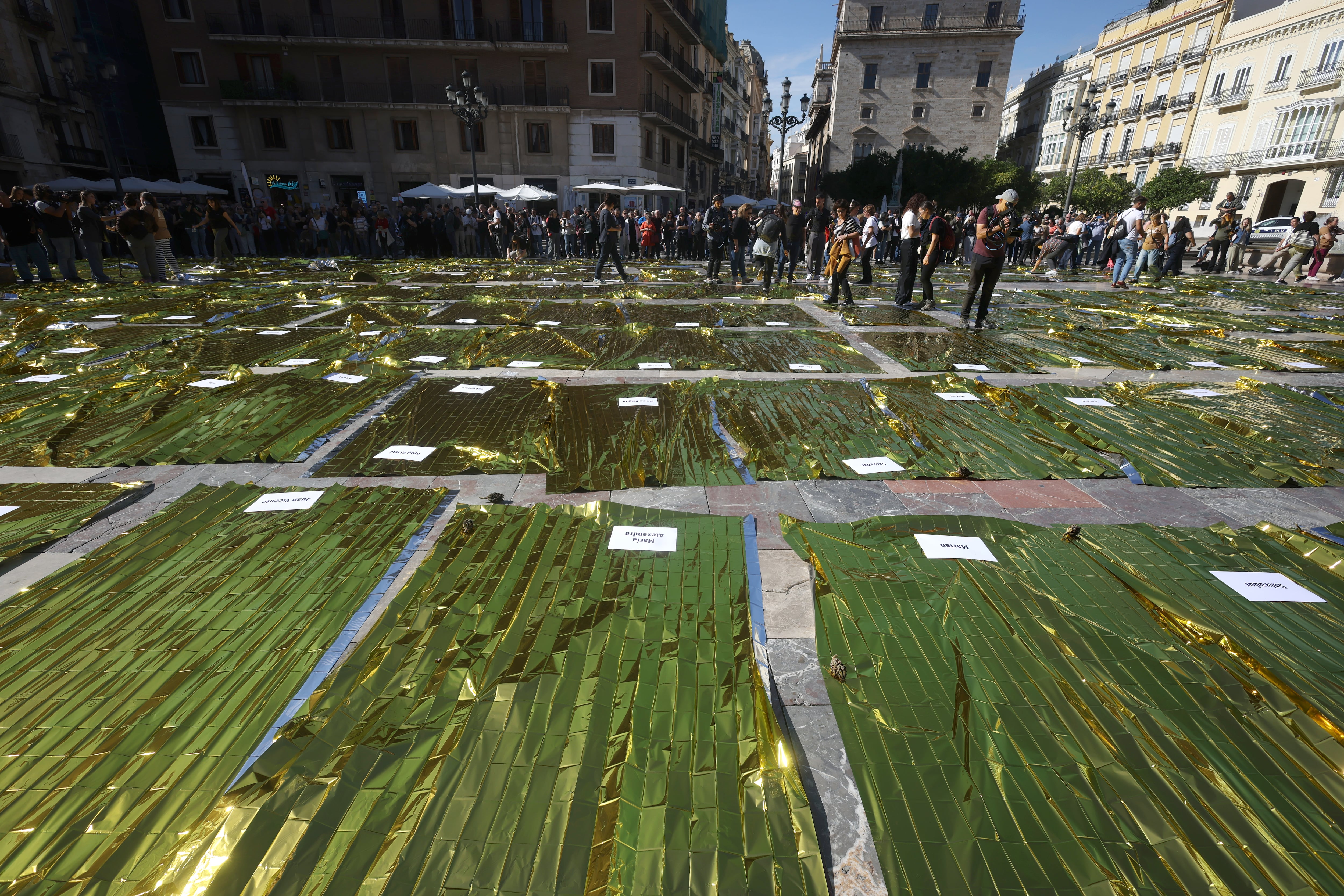 Mantas térmicas con los nombres de los muertos en la dana este miércoles en la plaza de la Virgen de Valencia.