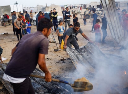 Un grupo de personas intentan apagar  las llamas tras el bombardeo israelí sobre un campo de desplazados en Rafah, este lunes. 